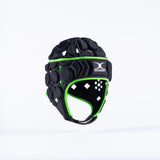 The Gilbert Octane Senior Headguard in Black/Green features a white Gilbert logo, padded chinstrap, and expandable lace closure, shown against a plain white background.