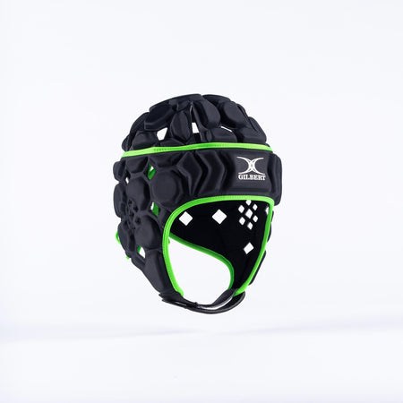 The Gilbert Octane Senior Headguard in Black/Green features a white Gilbert logo, padded chinstrap, and expandable lace closure, shown against a plain white background.