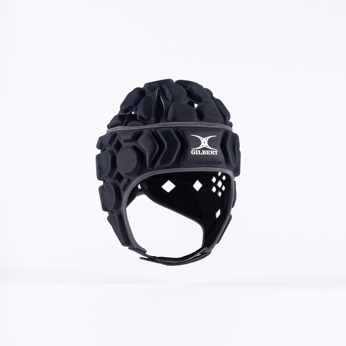The Gilbert Octane Senior Headguard in black/grey by Gilbert features geometric foam patterns, a padded chinstrap, ventilation holes, and an expandable lace closure, shown against a plain white background.