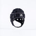 The Gilbert Octane Senior Headguard in black/grey by Gilbert features geometric foam patterns, a padded chinstrap, ventilation holes, and an expandable lace closure, shown against a plain white background.