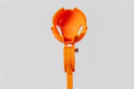 The RapidArm+ Ball Thrower by RapidArm is an orange plastic cricket training tool with a round, vented cup top and handle, shown against a plain light background.