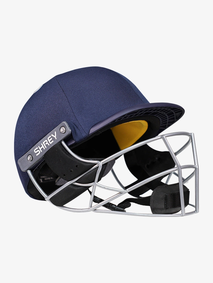 The Shrey Elite Pro Stainless Steel Helmet is a navy blue cricket helmet with a yellow interior, high-impact protection from its stainless steel grille, and SHREY branding on the side.