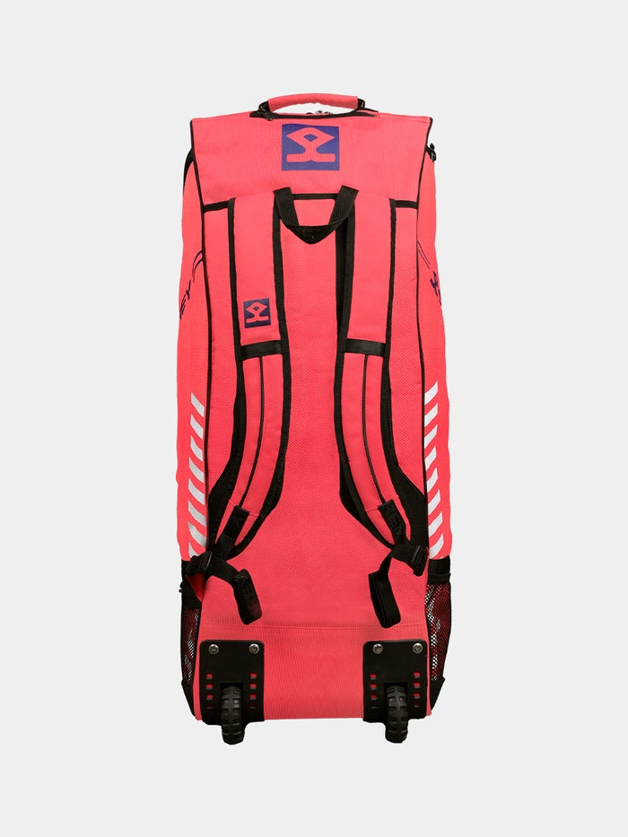 The Shrey Legacy Duffle Wheelie 80 is a bright pink cricket kit bag with black straps, mesh side pockets, wheels, a top handle, bold white accents, and blue-and-red Shrey logos—perfect for carrying your 80L cricket gear.