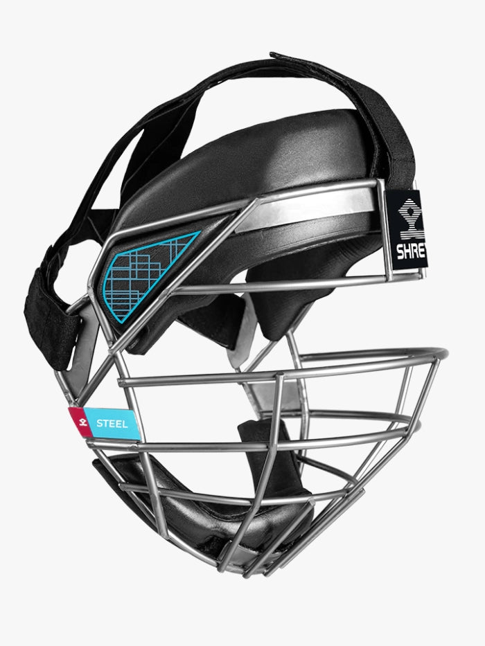 A close-up side view of the Shrey Stainless Steel Face Mask helmet shows its black padded top, stainless steel face mask, and blue and red SHREY brand labels.