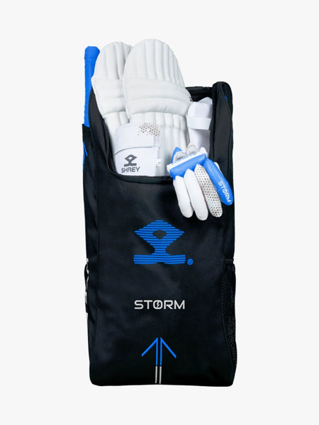 A black and blue Shrey Storm Cricket Set (Kashmir Willow) bag holds pads, gloves, a helmet, and bat; the set's handles and edges are visible at the top.