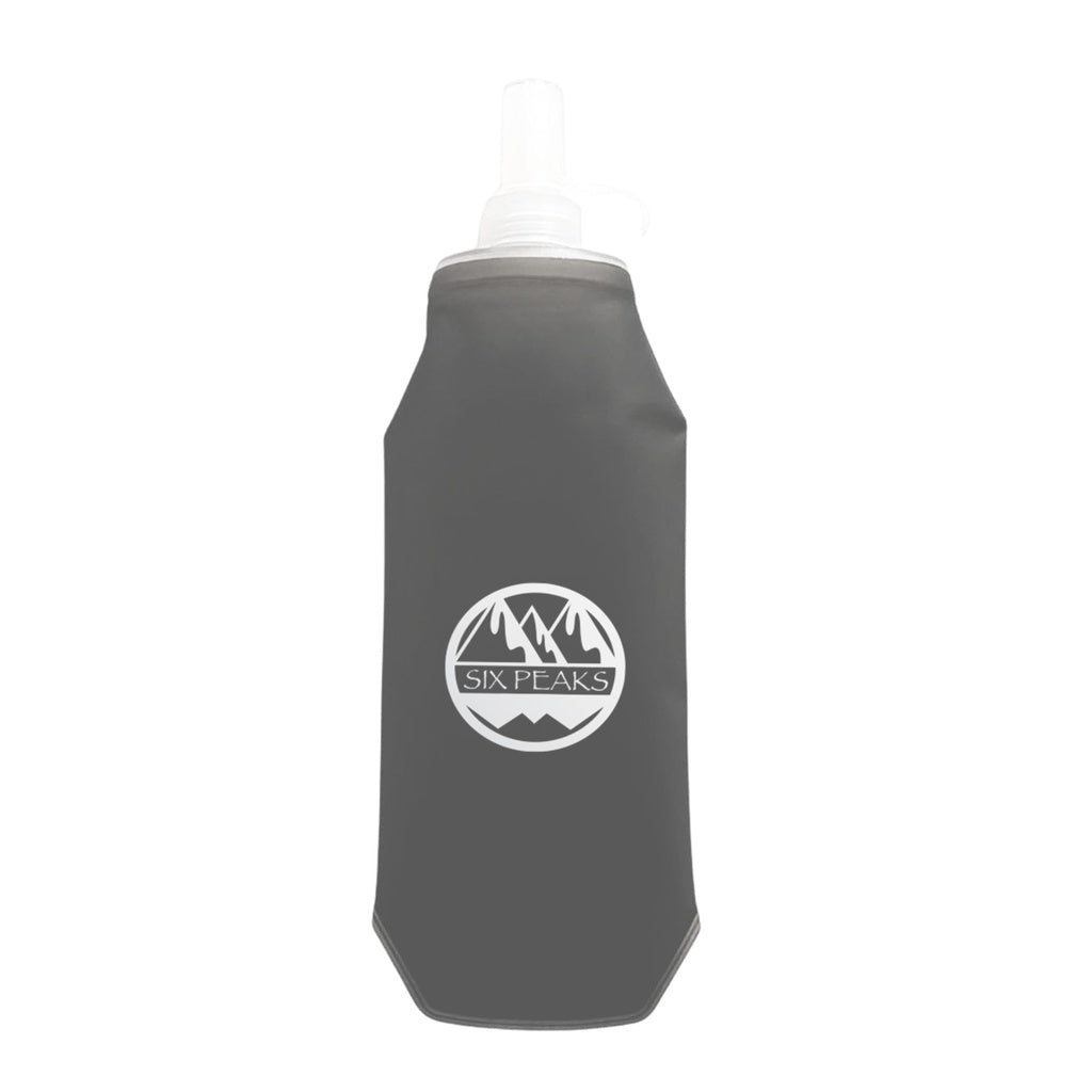 The Six Peaks Collapsible Water Bottle is a gray, travel-friendly bottle featuring a white Six Peaks logo with mountain graphics on the front and a transparent nozzle at the top.