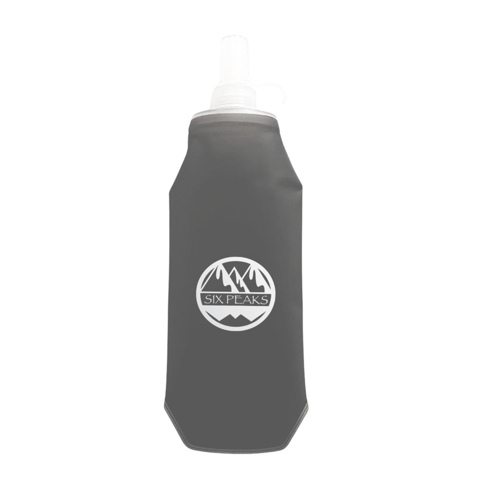 The Six Peaks Collapsible Water Bottle is a gray, travel-friendly bottle featuring a white Six Peaks logo with mountain graphics on the front and a transparent nozzle at the top.