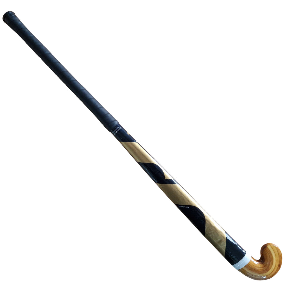 The Mercian Scorpion FGB Hockey Stick features a black handle, curved wooden lower end, and a black and gold diagonal stripe on the shaft with a durable fibreglass wrap.