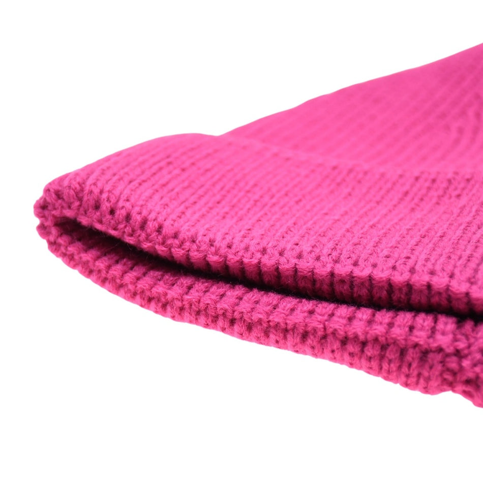 A close-up of a folded, bright pink Six Peaks brand Six Peaks Beanie knit hat against a white background.