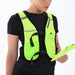 Wearing the Six Peaks Hydration Running Vest in Safety Yellow over a black shirt, a person holds a matching yellow item while looking at it against a plain white background. Brand: Six Peaks.