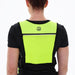 A person wears the Six Peaks Hydration Running Vest in bright yellow-green over a black shirt, shown from the back against a plain white background—ideal for trail running safety.