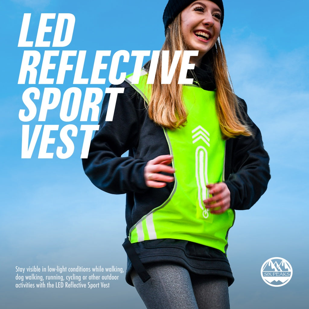 A smiling woman jogs outdoors wearing the Six Peaks LED Reflective Sport Vest. Large text features the product name, with smaller highlights on visibility and safety. The Six Peaks logo appears in the corner.