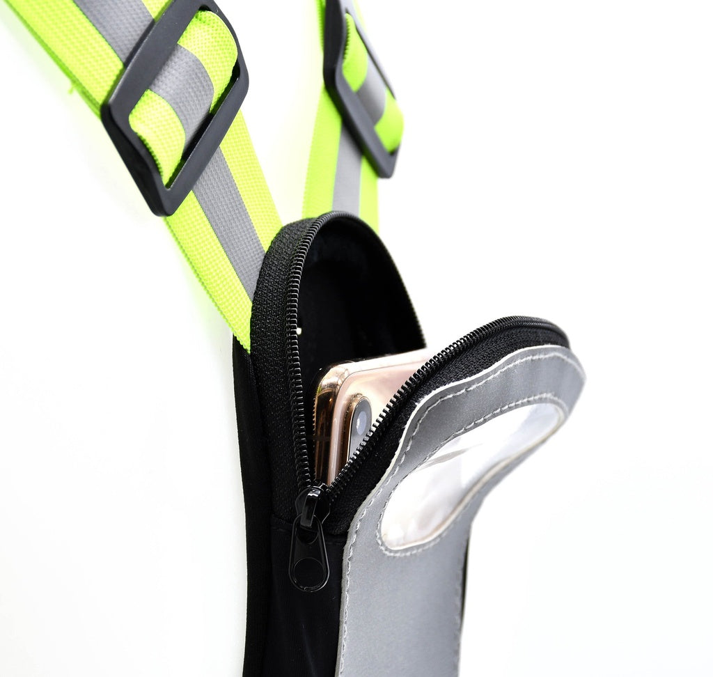 Close-up of the Six Peaks LED Reflective Vest with Phone Holder, featuring fluorescent yellow straps, black buckles, and a gray zippered pouch by Six Peaks attached to the harness, holding a partially visible smartphone.
