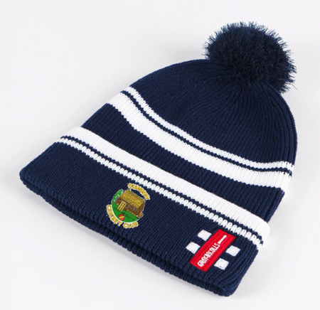 The Gray Nicolls Stanway CC Navy Bobble Hat features white stripes, a fluffy pom-pom, embroidered club logo, and a red patch—ideal for showing your team spirit.