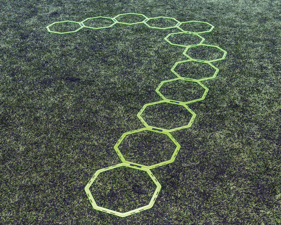 Twelve Precision Training Octa Rings are arranged on grass in a question mark shape, showcasing the versatile Precision Octa Ring System.