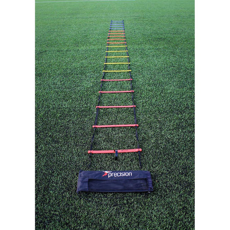 The Precision Training Speed Ladder with multicolored rungs is laid on green grass for footwork drills, and a black Precision Training bag sits at the end nearest the camera.