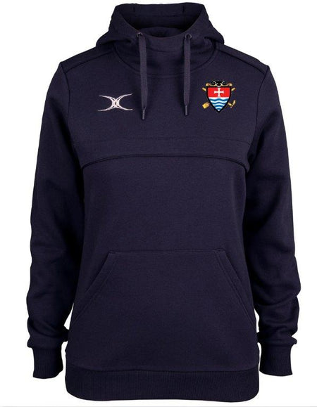 The Teign School Womens Photon Hoodie by Gilbert is a navy blue rugby hoodie with a drawstring, featuring a small emblem on the left chest and a white and red shield crest with blue stripes and gold accents on the right chest.