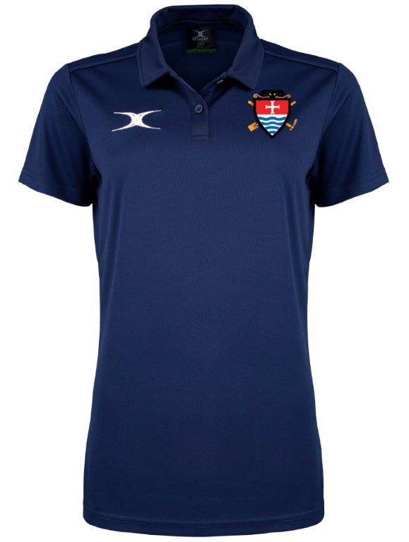 The Gilbert Teign School Womens Photon II Polo Shirt is navy blue, short-sleeved with buttons, has a white right-chest logo and a left-chest crest with crossed hockey sticks and shield—ideal for Teign School wear.
