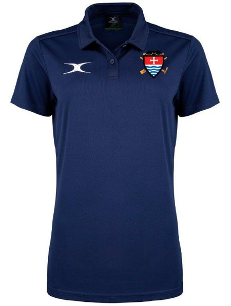 The Gilbert Teign School Womens Photon II Polo Shirt is navy blue, short-sleeved with buttons, has a white right-chest logo and a left-chest crest with crossed hockey sticks and shield—ideal for Teign School wear.