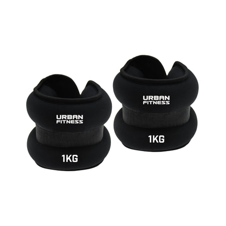 Two black Urban Fitness Neoprene Ankle/Wrist Weights, each labeled "Urban Fitness" and "1KG," can be used on the wrists or ankles. Both weights are shown side by side on a white background.