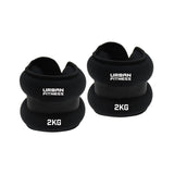 Two black Urban Fitness Neoprene Ankle/Wrist Weights, each 2KG, are shown against a white background. Featuring a soft padded design and secure strap, these versatile weights by Urban Fitness are perfect for wrists or ankles.
