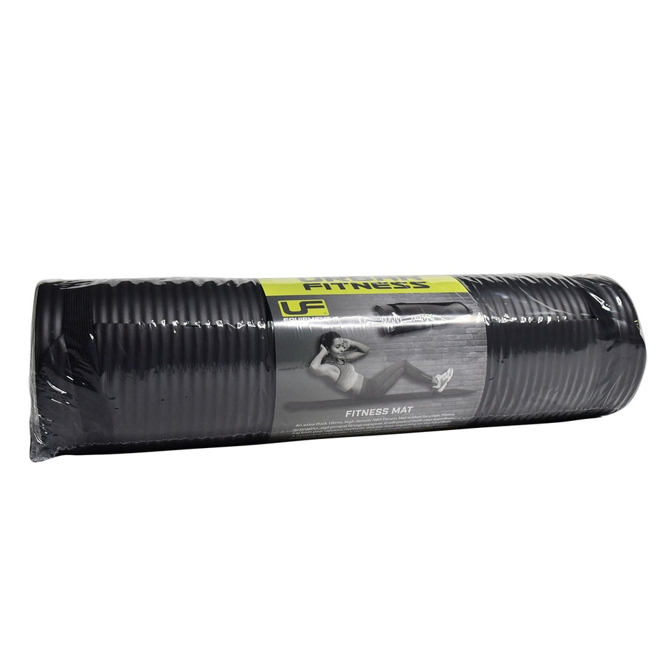The Urban Fitness NBR Fitness Mat 10mm is a black mat rolled in plastic with a yellow and gray label featuring a woman exercising, the words "Fitness Mat" on the front, and offers 10mm cushioning for extra comfort.