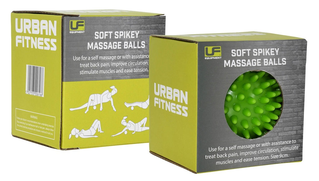 Two green Urban Fitness Soft Spikey Massage Balls boxes: one explains their benefits for circulation and back pain, the other features a cut-out window showing a green spikey massage ball inside.
