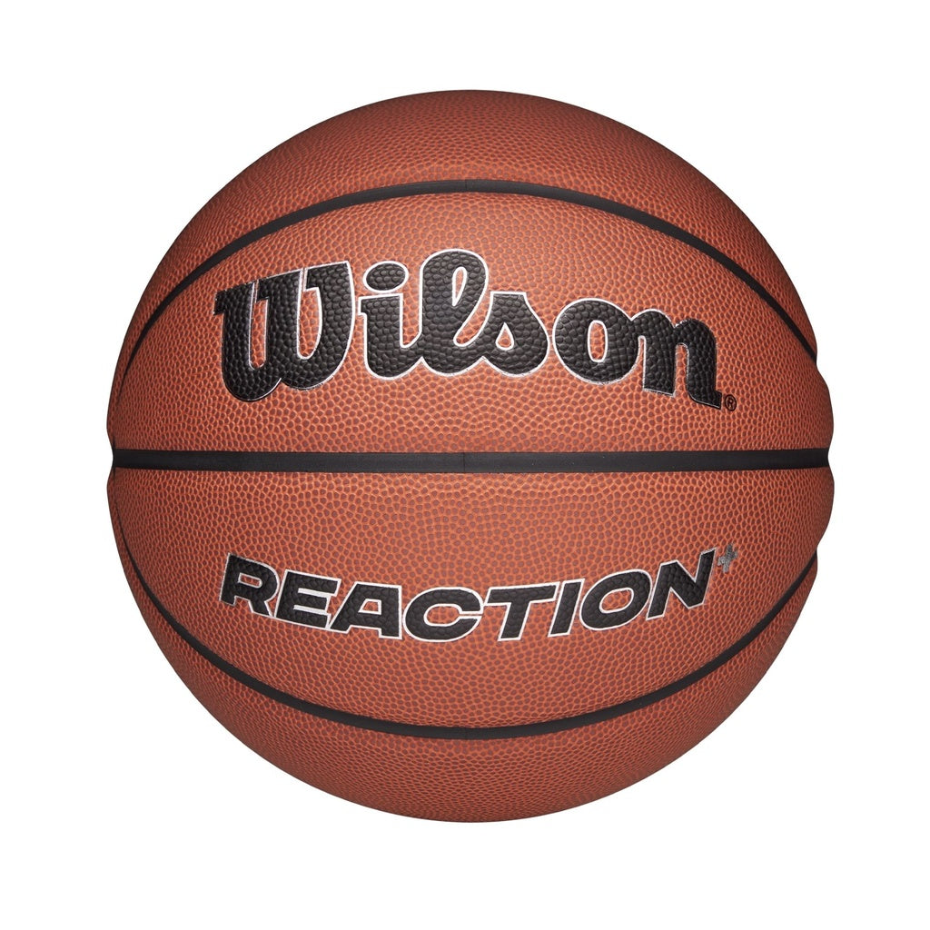The Wilson Reaction Plus Basketball features a brown composite cover with black lines and "Wilson" boldly above "REACTION." Suitable for indoor and outdoor play, it is shown against a plain white background.