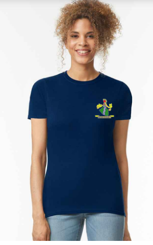 A smiling woman with curly hair wears a fitted navy PenCarrie Westbury-on-Severn CC Gilden Ladies T-shirt with a small colorful graphic on the left chest and light blue jeans, standing against a plain white background.