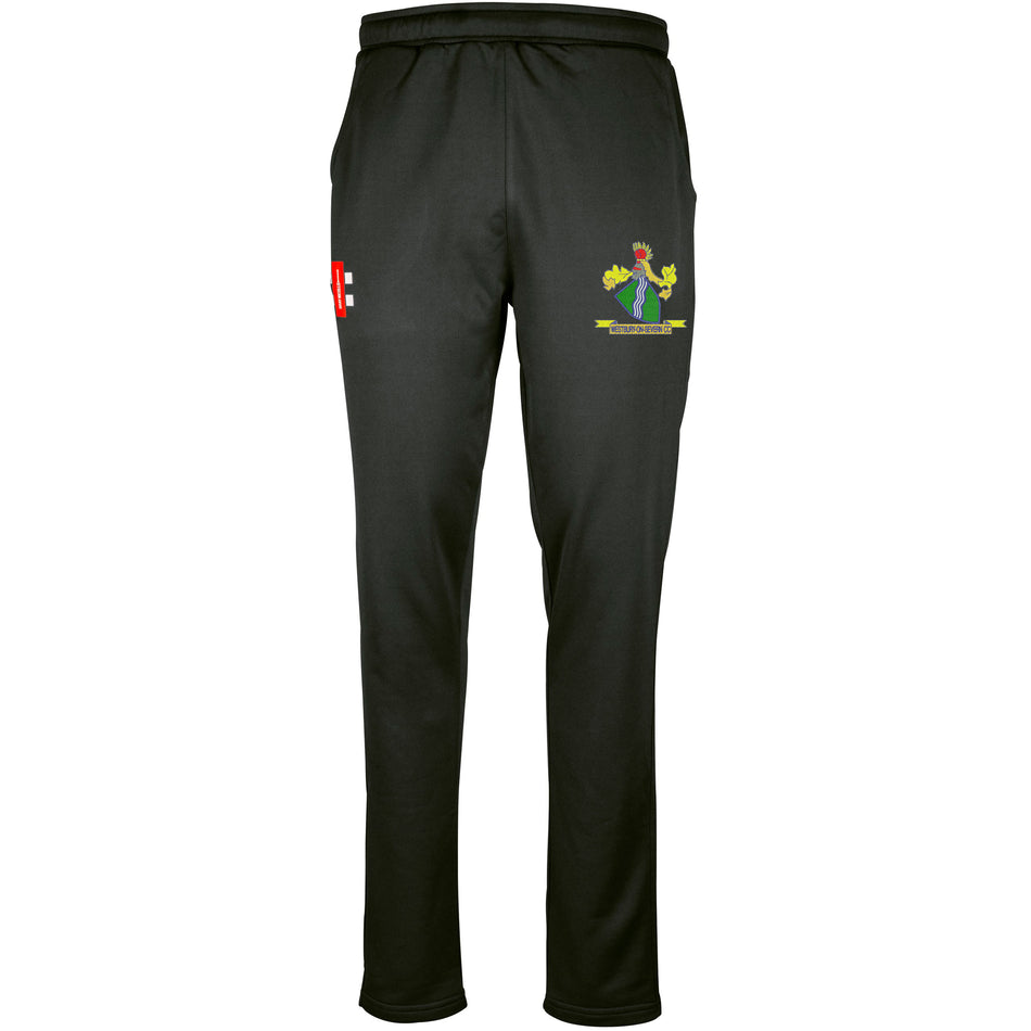The Gray Nicolls Westbury-on-Severn CC Pro Performance Training Trousers are black with an elastic waistband, moisture-wicking fabric, a red and white NE logo on the right thigh, and a green, blue, and yellow crest on the left thigh.