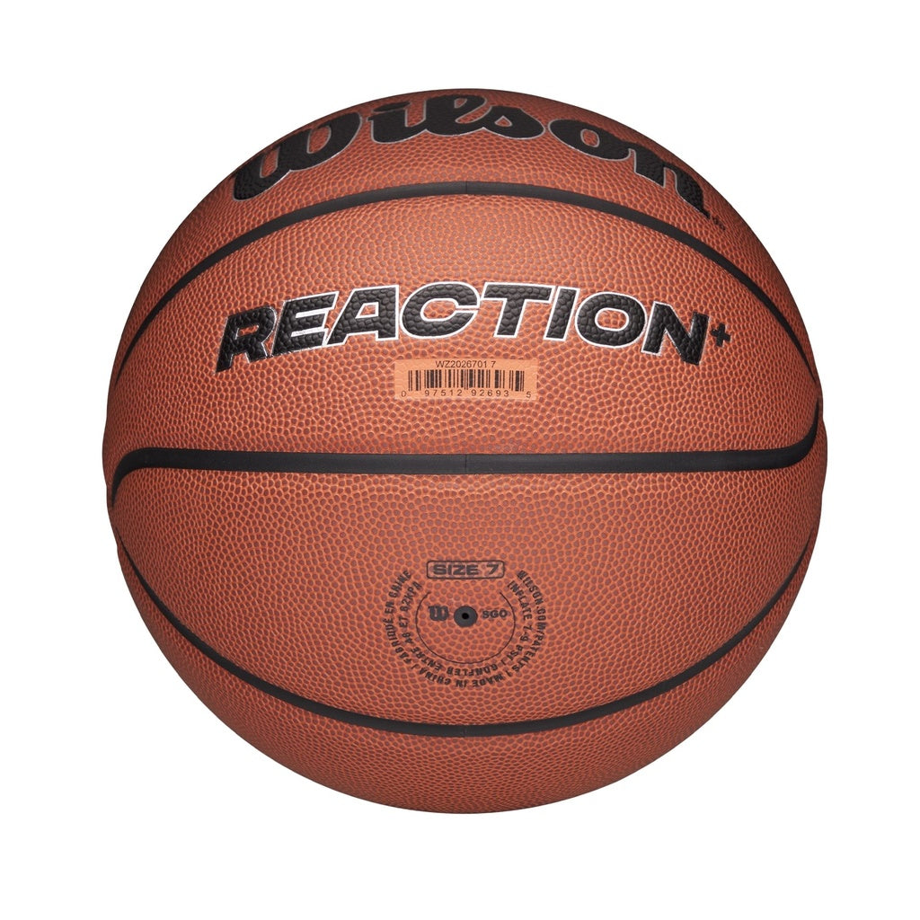 The Wilson Reaction Plus Basketball by Wilson features a brown textured composite cover with black "REACTION+" text, barcode, and size 7 marking. Suitable for indoor and outdoor play, it's displayed against a white background.