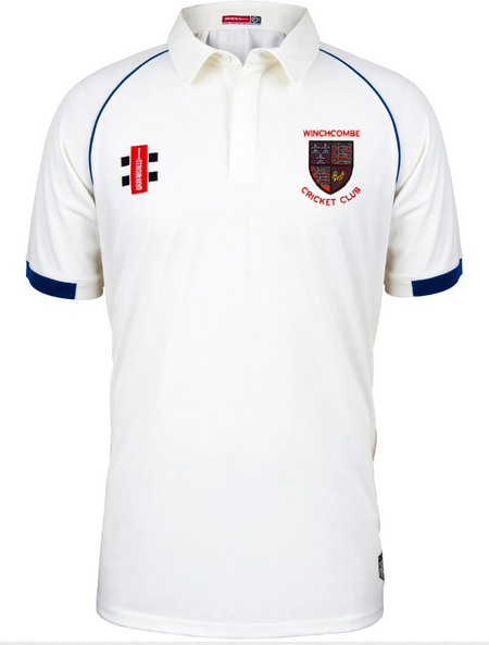 The Gray Nicolls Winchcombe CC Matrix V2 Short Sleeve Match Shirt is white with blue trim, a collar, the club crest and “WINCHCOMBE CRICKET CLUB” on the left chest, plus two black stripes and a red patch on the right chest.