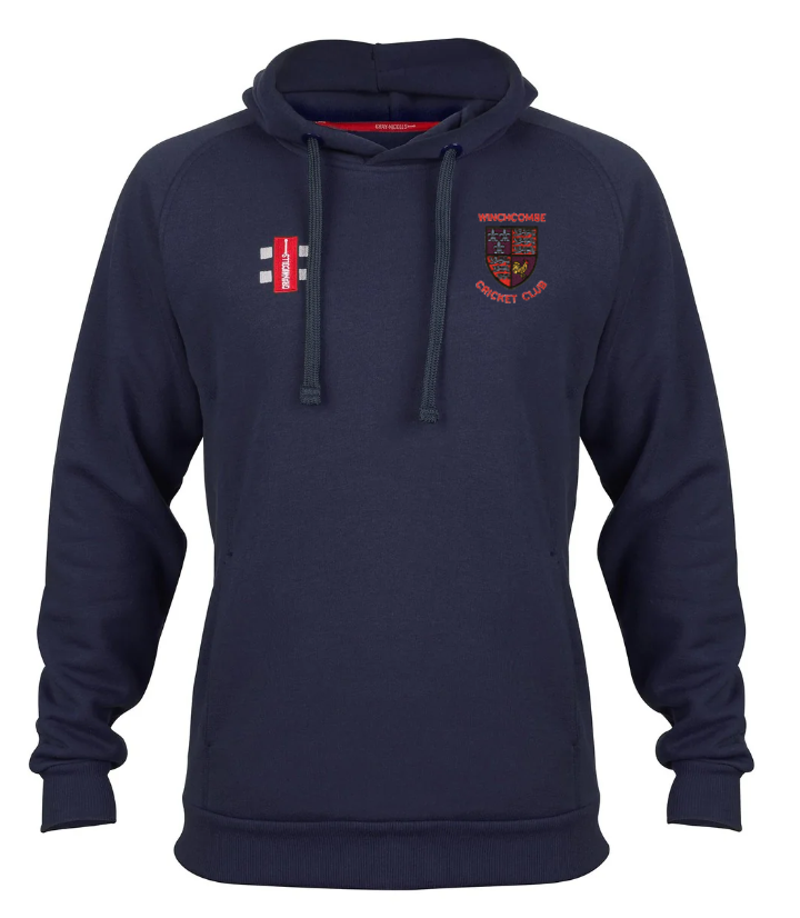 The Gray Nicolls Winchcombe CC Velocity Hoodie is navy blue, made from sustainable cotton, and features a front pocket, drawstrings, and embroidered red and white Winchcombe CC logos with a coat of arms on the left chest.