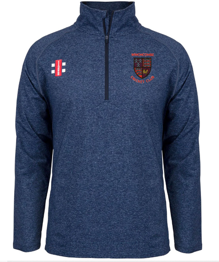 The Gray Nicolls Winchcombe CC Velocity Mid Layer is a navy blue stretch-fit quarter-zip pullover, featuring a small red, white, and navy logo on the right chest and an embroidered Wycombe Cricket Club crest on the left.