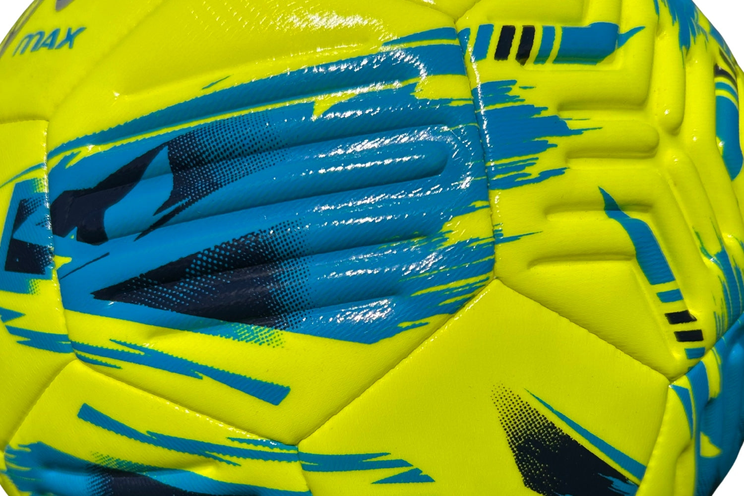 Close-up of the Samba Infiniti Max Training Ball by Samba Sports, featuring a vibrant yellow design with blue and black abstract patterns. The textured surface and detailed stitching of the panels are clearly visible, while precision-moulded grooves enhance control—making it ideal for use as a training football.