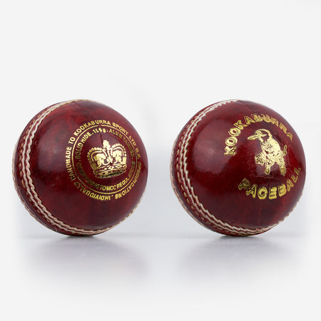 Two red Kookaburra Pace Cricket Balls by Kookaburra, with white stitching and gold branding, are displayed side by side on a plain white background. Each is hand sewn with a durable hide cover.