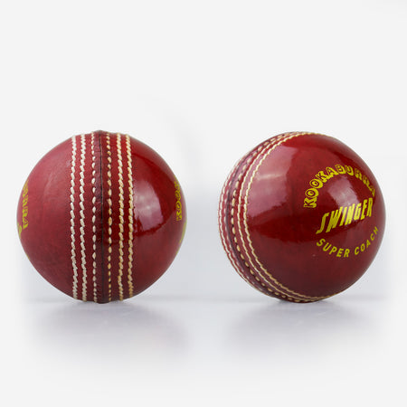 Two shiny red Kookaburra Super Coach Swinger leather cricket balls with white stitching—one shows the seam, while the other displays Kookaburra branding—ideal for swing training on a plain white background.