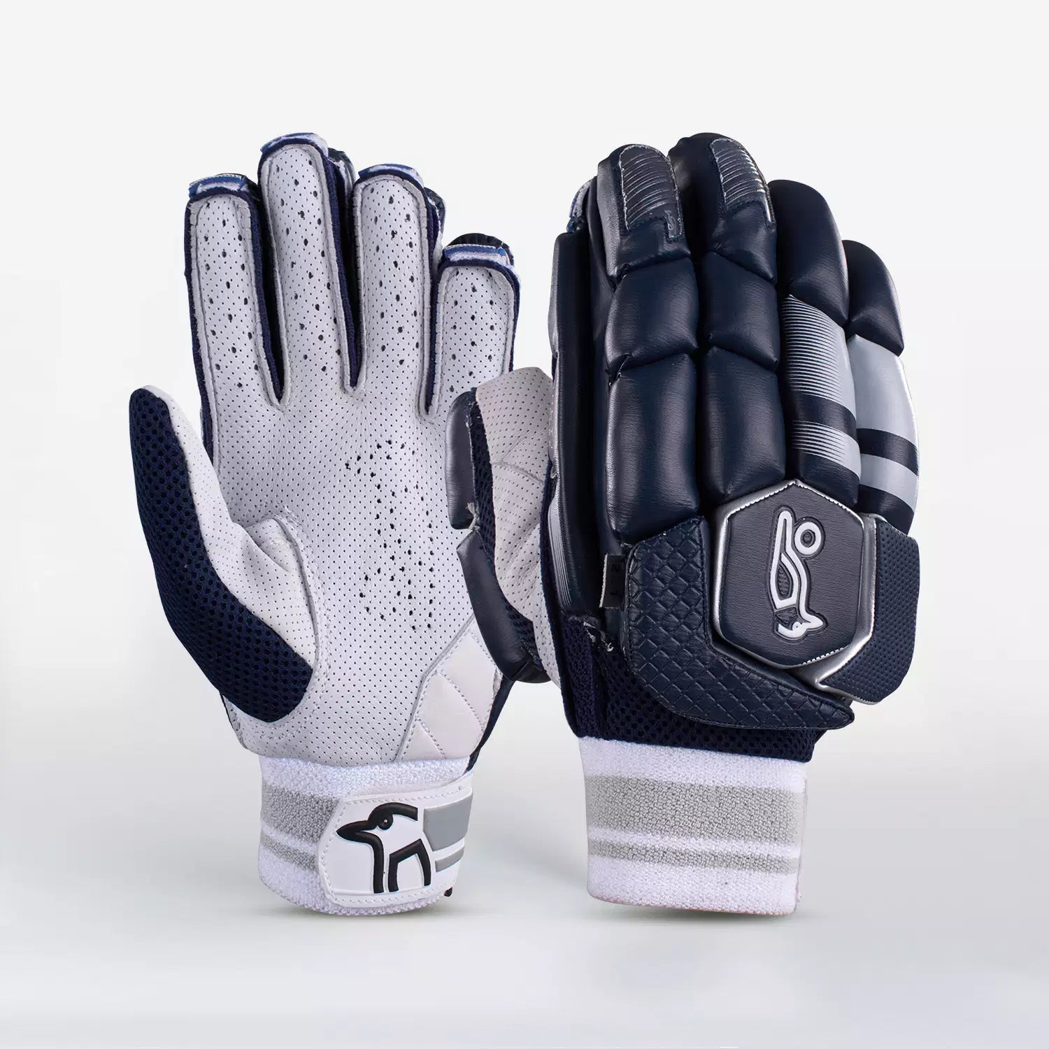 The Kookaburra 2.1 T/20 Batting Gloves by Kookaburra feature a navy palm side in supple sheep leather with perforations, and a padded back with black, grey, and white high-density foam detailing plus a stylized logo.