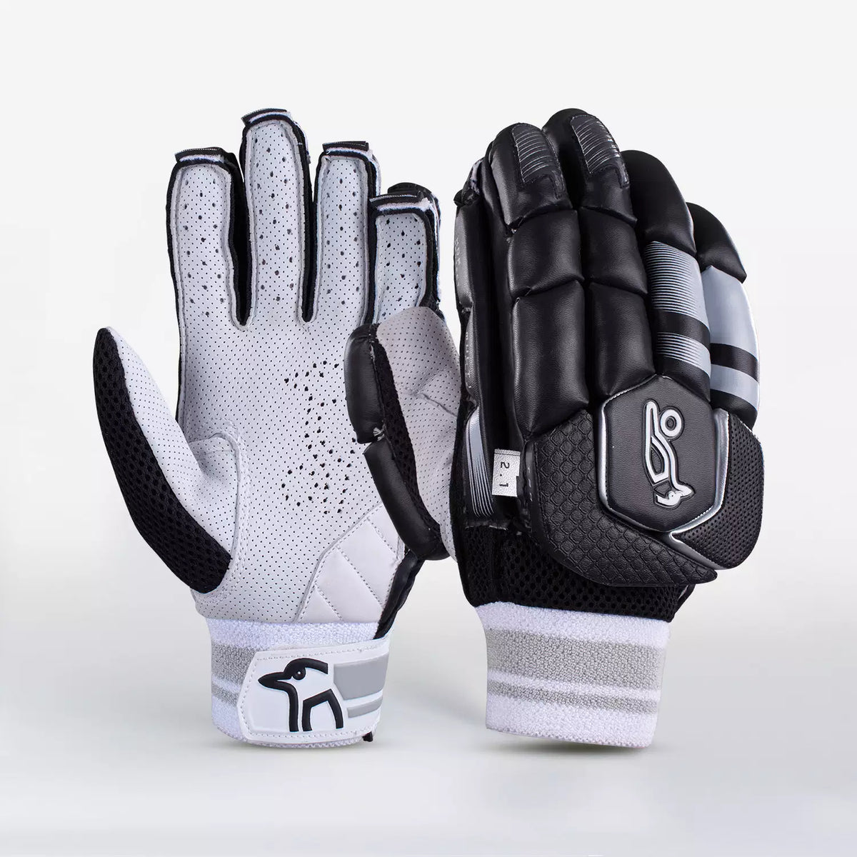 The Kookaburra 2.1 T/20 Batting Gloves by Kookaburra feature premium sheep leather palms, high-density foam padding, and a striking black design with grey and white details—offering both ventilation and protection for cricketers.