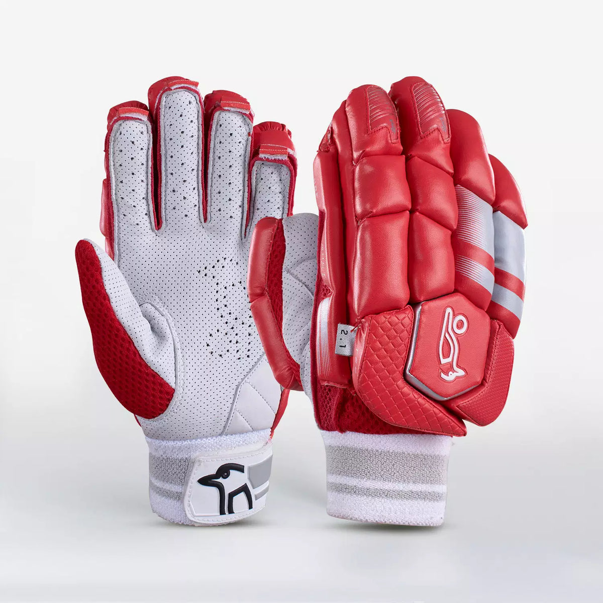 The Kookaburra 2.1 T/20 Batting Gloves by Kookaburra are shown in red, featuring sheep leather, a padded back with high-density foam, ventilated white palms, embroidered logos, and red accents—all displayed on a white background.