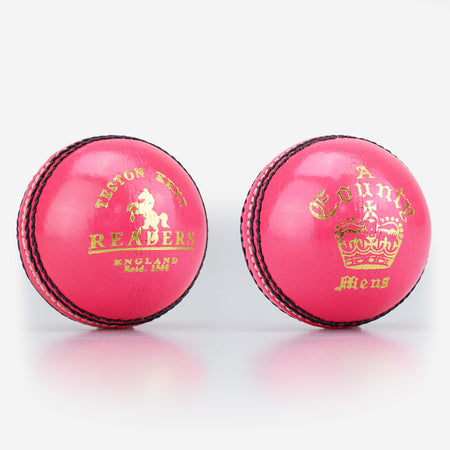 Two pink Readers County Crown Coloured Cricket Balls with black stitching and shiny leather surfaces, ideal for training or evening matches, are set on a white background. Each features distinctive gold branding: the Readers logo and a crown.