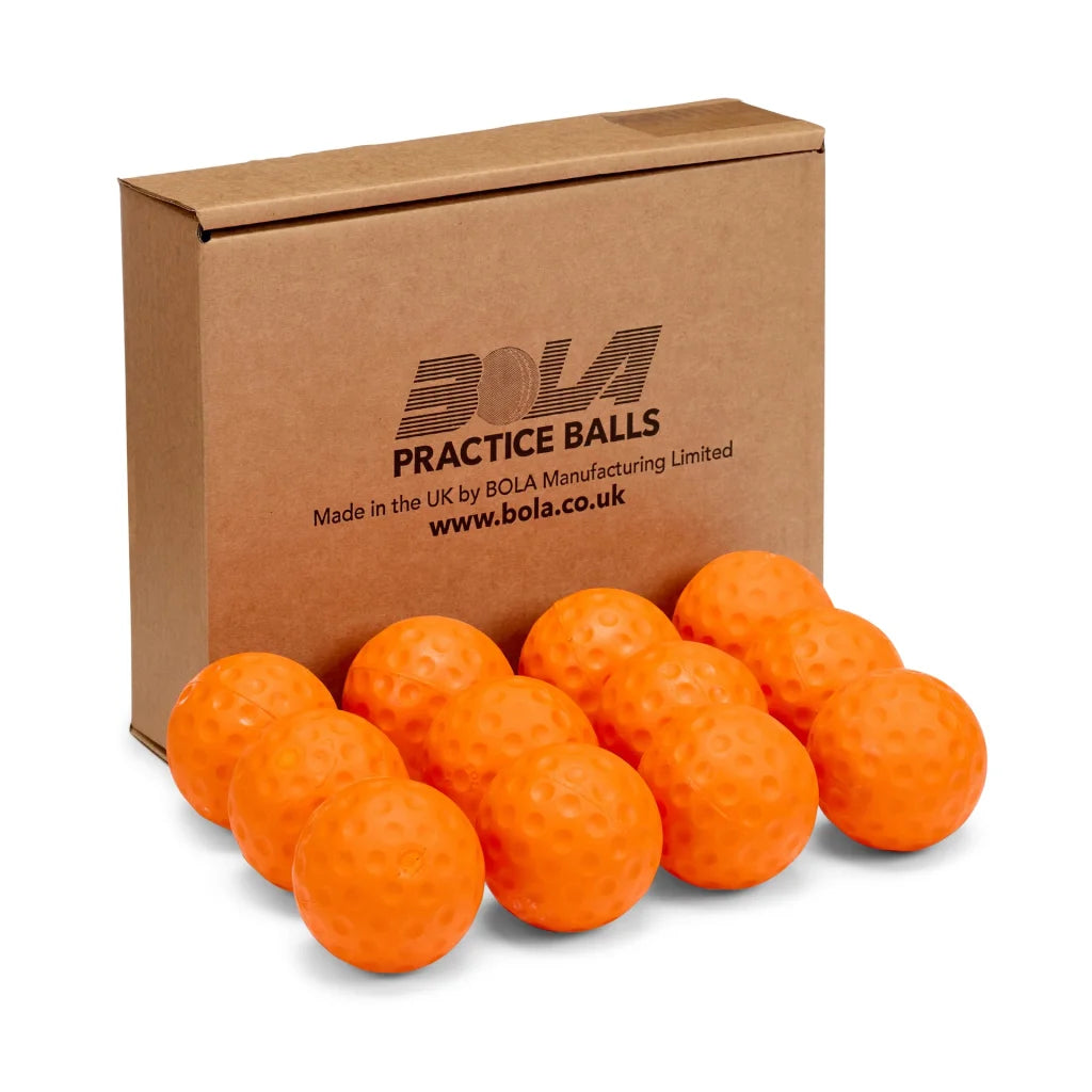 A brown box labeled with the Bola brand sits behind a dozen bright orange, dimpled Bola Junior Bowling Machine Practice Balls—arranged in two rows—perfect for use with your Junior Bowling Machine.