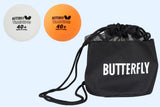 Two Butterfly 100 Training Balls, one white and one orange, are placed next to a black carry bag with “Butterfly” printed in white letters.