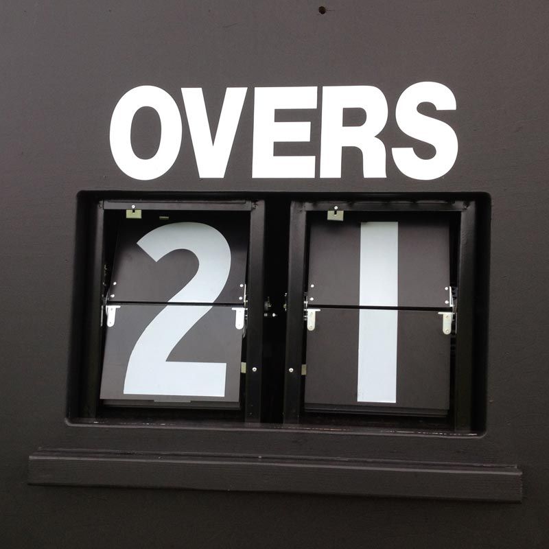 The R J Hill Engineering Mechanical Scorer Numbers (0-9) Plus Blank display "21" overs bowled on a black scoreboard with anti-glare plates and a powder-coated steel case, with "OVERS" shown above the score.