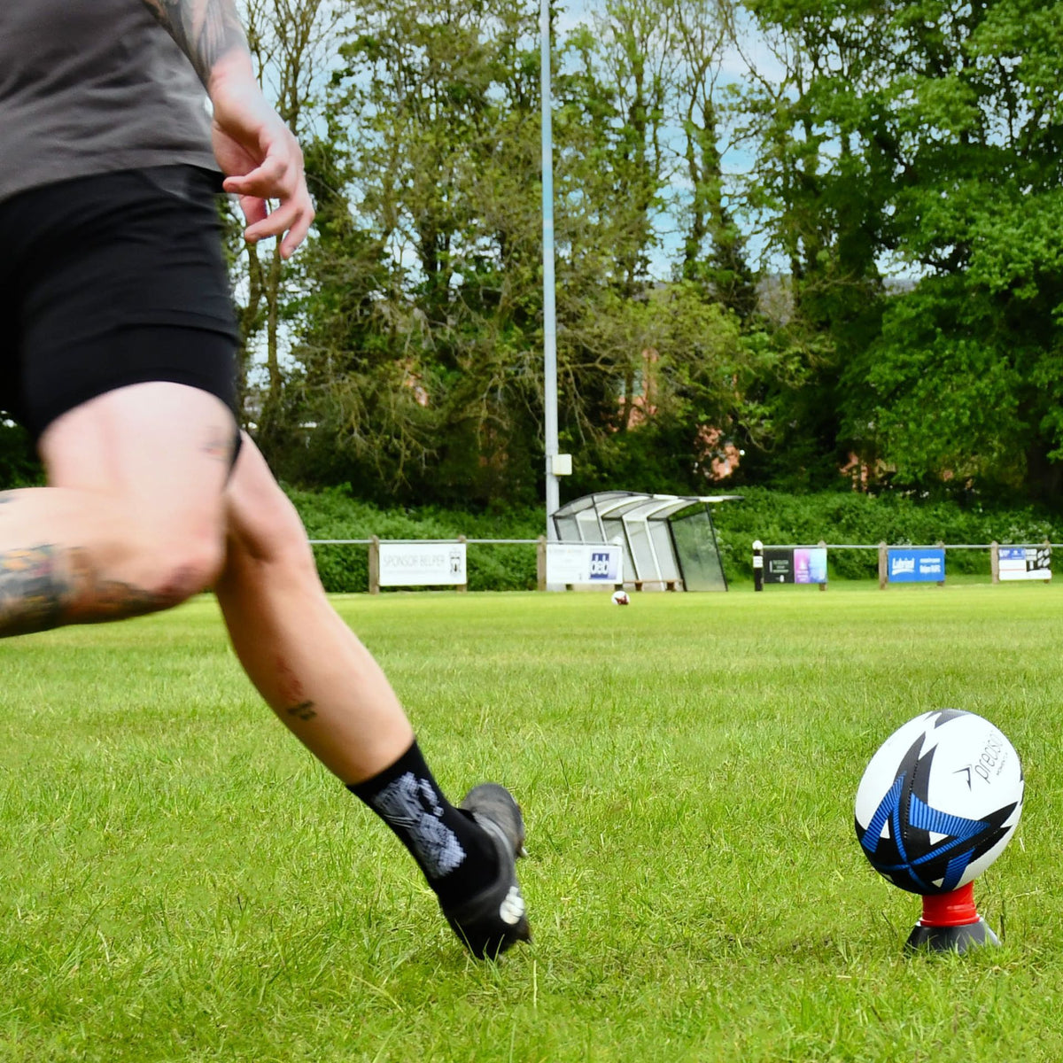Player kicking the blue Precision Momentum Rugby Training Ball off a tee