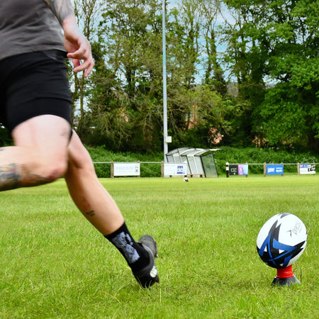 Player kicking the blue Precision Momentum Rugby Training Ball off a tee