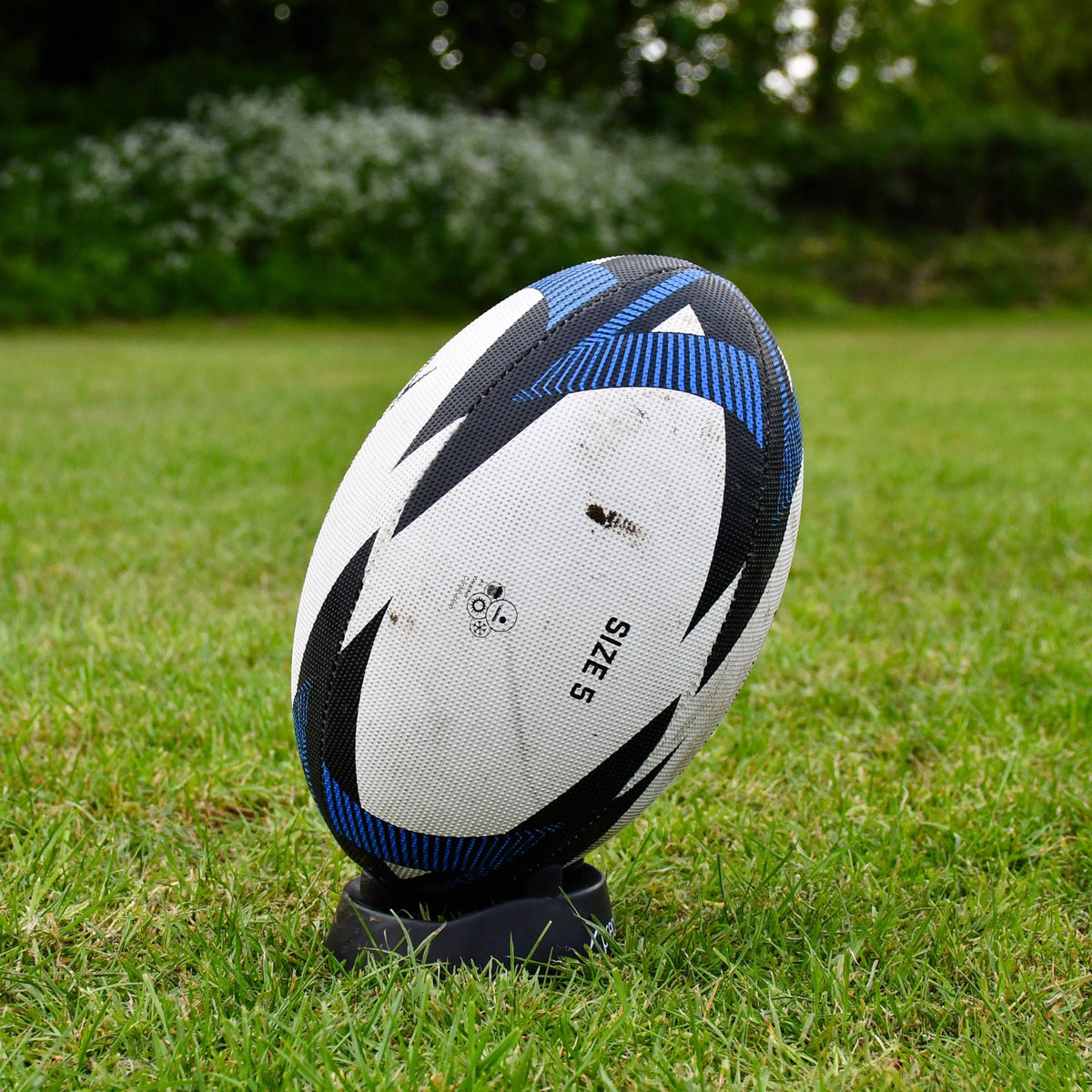 Close-up angled view of the blue Precision Momentum Rugby Training Ball on a kicking tee