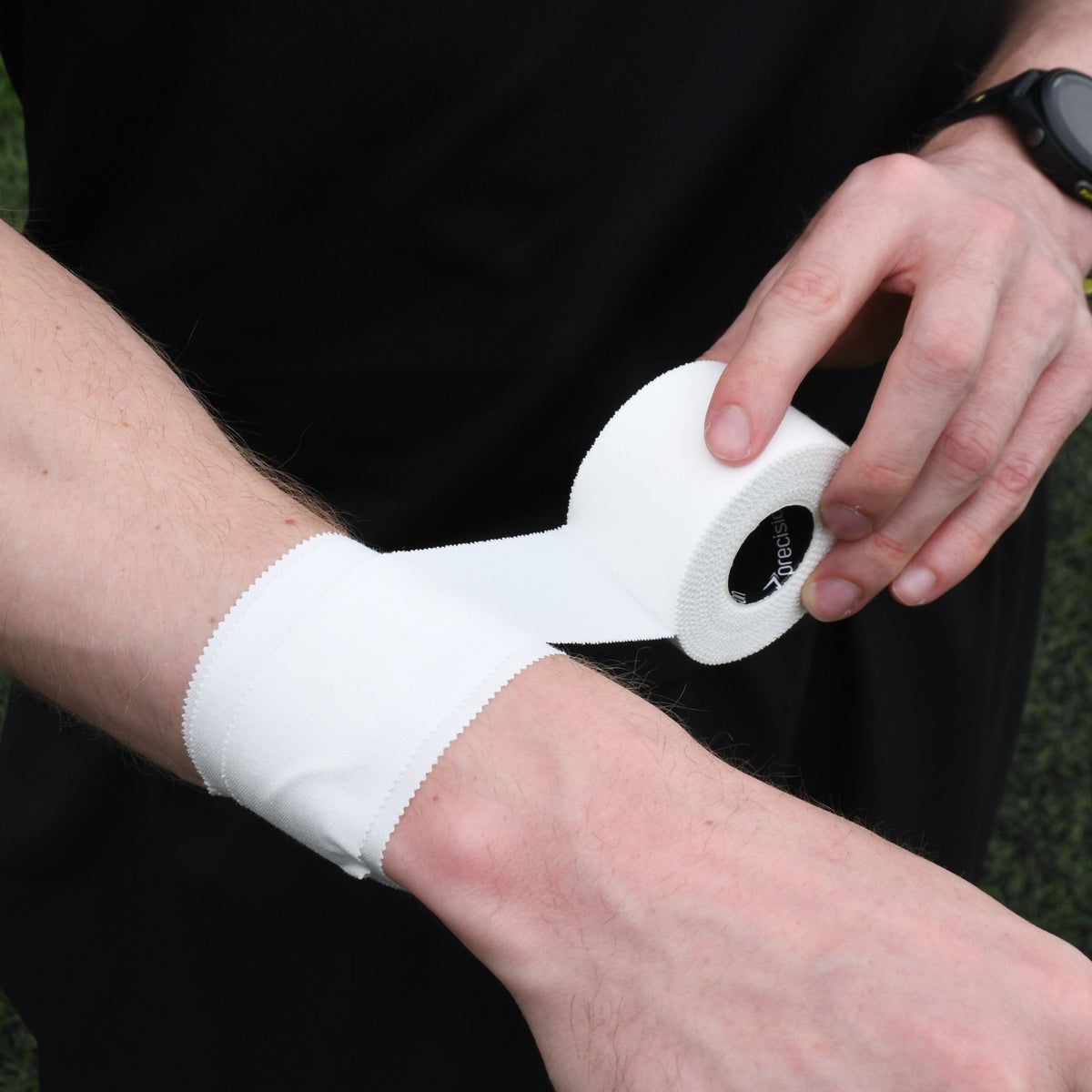 White Precision zinc oxide tape being applied around the wrist for joint support