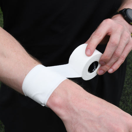 White Precision zinc oxide tape being applied around the wrist for joint support