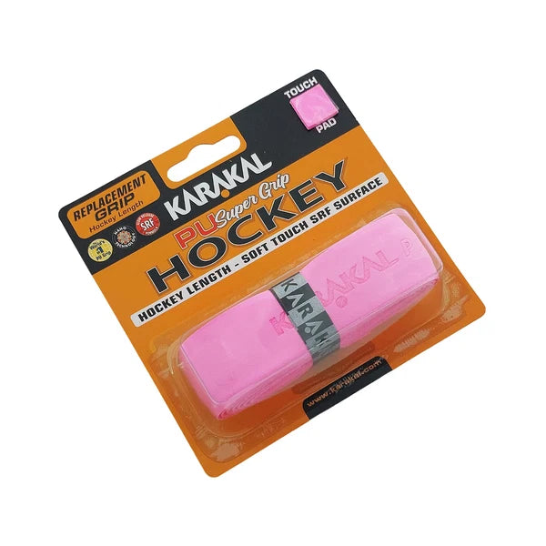 A packaged pink Karakal XL PU Super Hockey Grip replacement grip, labeled as soft touch with SRF surface, features a cushioned PU grip and is displayed on an orange and black backing card.
